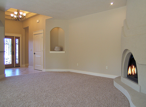 Hanging entry chandelier in coved ceiling, custom 9 ft. stucco wall with arched  fireplace...
