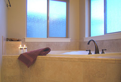Light-filled bath features frosted glass,...