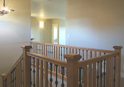 Rich stairway with wood rails & wrought-iron post, contemporary hanging chandelier...